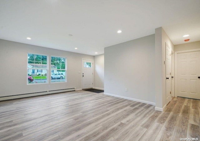 interior space with light wood-type flooring and a baseboard radiator