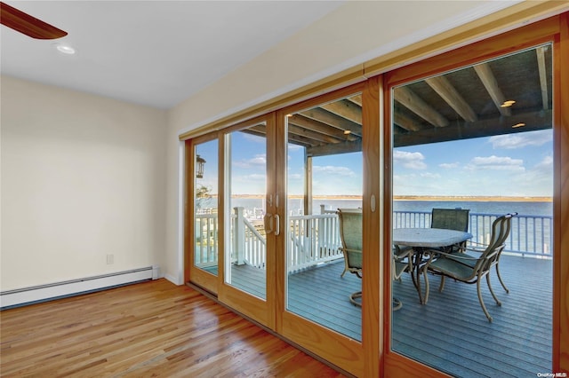 entryway featuring ceiling fan, french doors, a baseboard heating unit, a water view, and light wood-type flooring