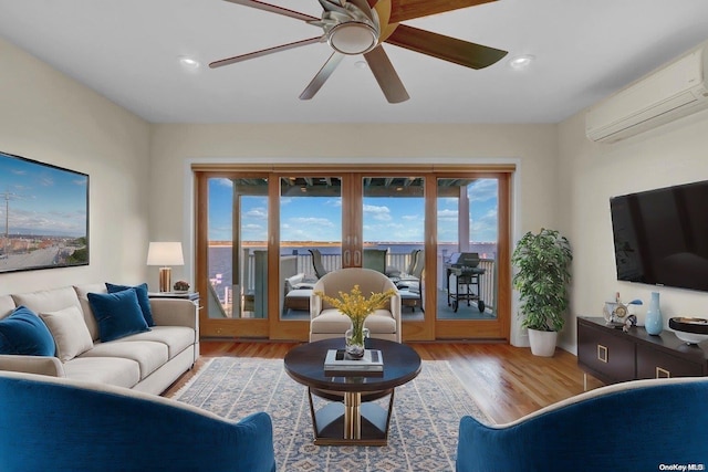 living room with hardwood / wood-style floors, an AC wall unit, and ceiling fan