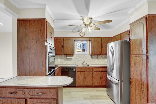 kitchen with sink, decorative backsplash, light wood-type flooring, ornamental molding, and stainless steel appliances