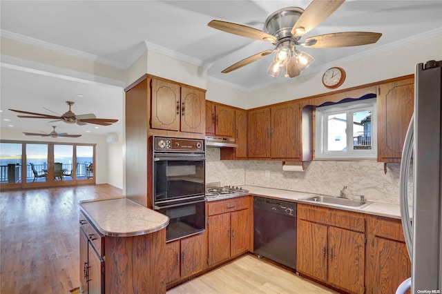 kitchen featuring tasteful backsplash, crown molding, sink, black appliances, and light hardwood / wood-style flooring