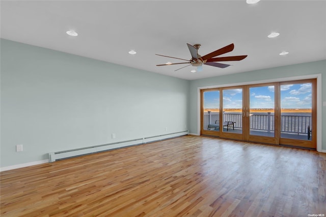 empty room with ceiling fan, light hardwood / wood-style flooring, and a baseboard radiator