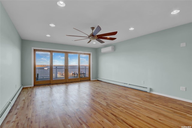 unfurnished room with light hardwood / wood-style floors, an AC wall unit, and a baseboard radiator