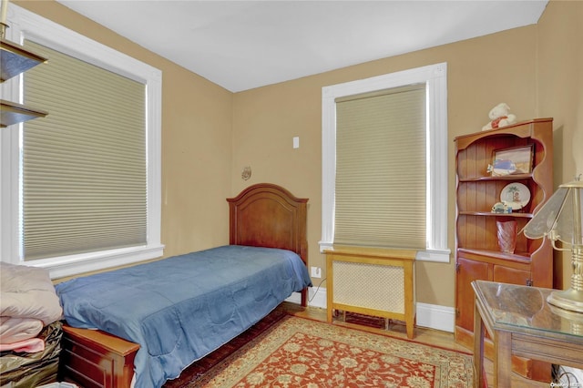 bedroom featuring light hardwood / wood-style flooring and radiator