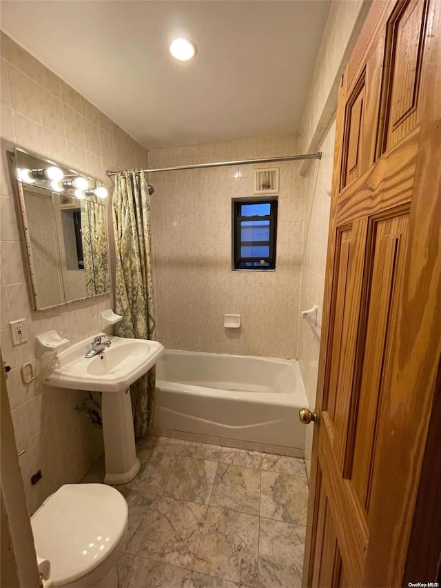 full bathroom featuring shower / bath combo, toilet, tile walls, and sink