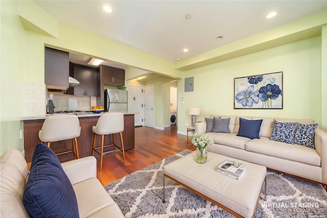 living room with washer / clothes dryer and dark hardwood / wood-style flooring