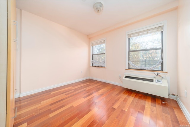 empty room featuring radiator heating unit and light wood-type flooring