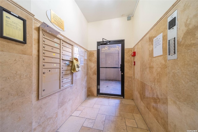 doorway with mail boxes and tile walls