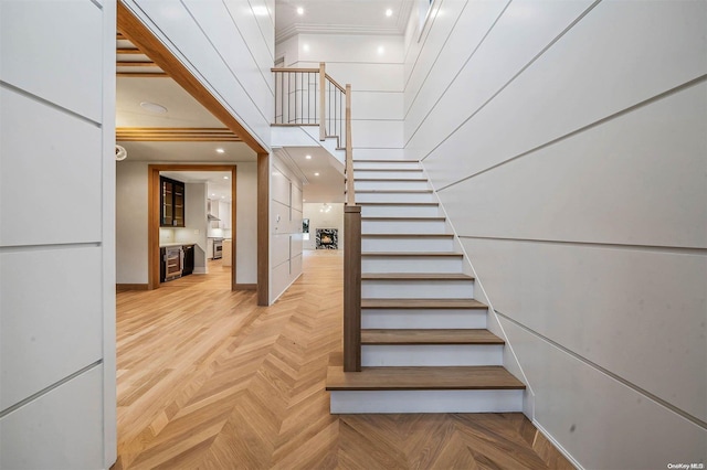 staircase featuring parquet floors and crown molding