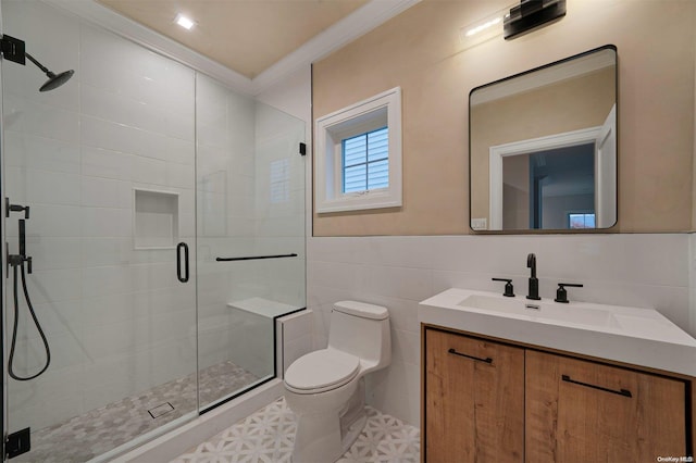 bathroom with toilet, vanity, a shower with shower door, tile walls, and ornamental molding