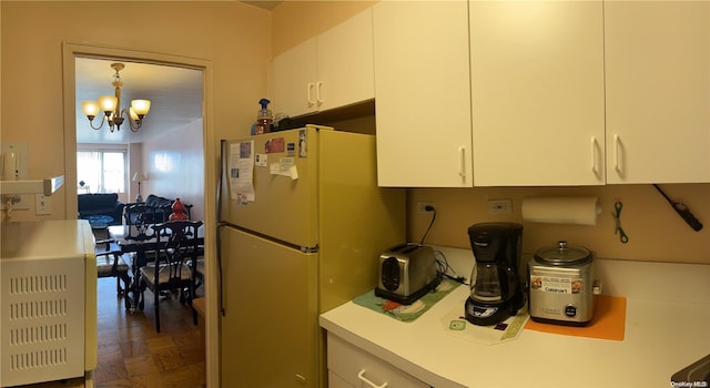 kitchen featuring dark parquet flooring, white cabinetry, white refrigerator, pendant lighting, and a chandelier