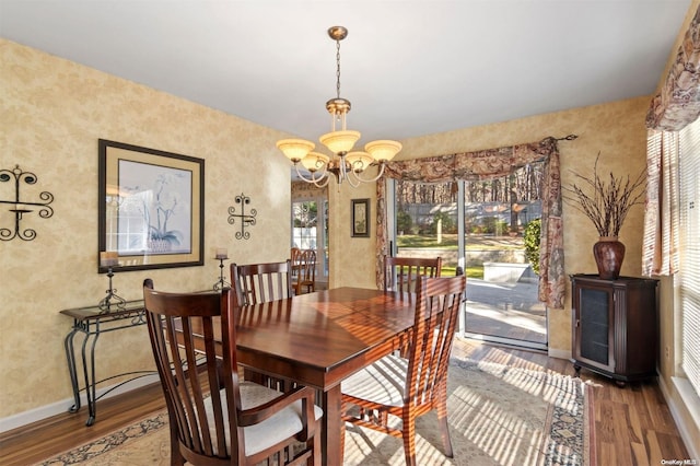 dining room with wood-type flooring, an inviting chandelier, and plenty of natural light