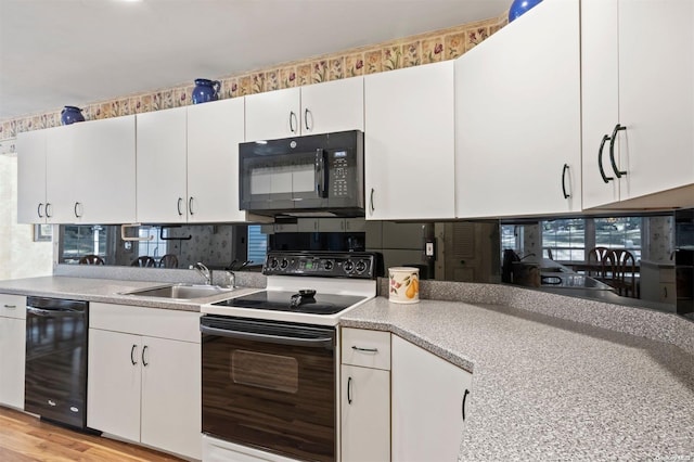 kitchen with decorative backsplash, light wood-type flooring, sink, black appliances, and white cabinetry