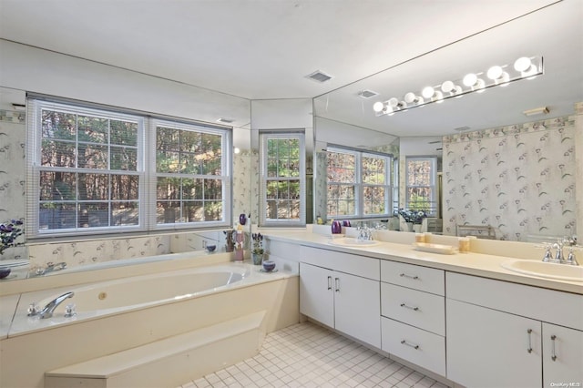 bathroom with a tub to relax in, tile patterned flooring, and vanity