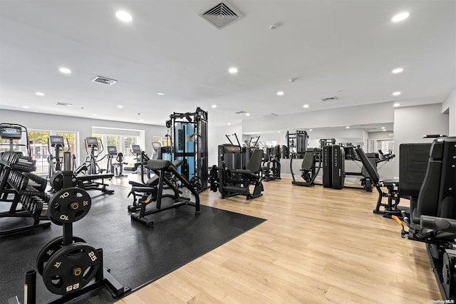 exercise room with light hardwood / wood-style flooring