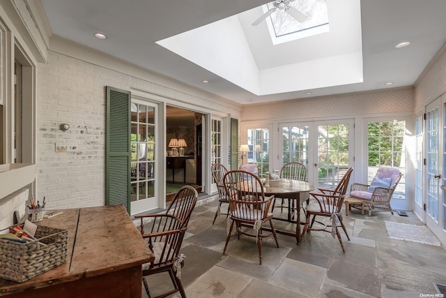 sunroom featuring vaulted ceiling with skylight, ceiling fan, and french doors