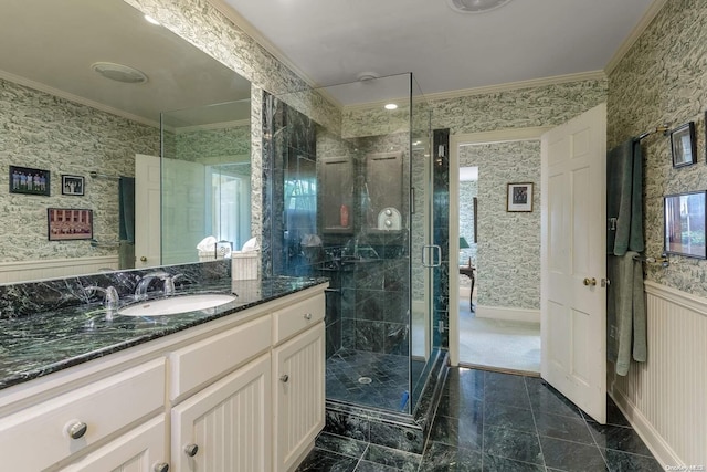 bathroom with vanity, crown molding, and a shower with shower door