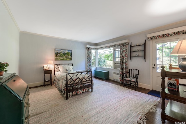 bedroom featuring multiple windows, radiator, ornamental molding, and hardwood / wood-style flooring