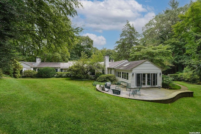 rear view of property featuring a lawn and a patio area