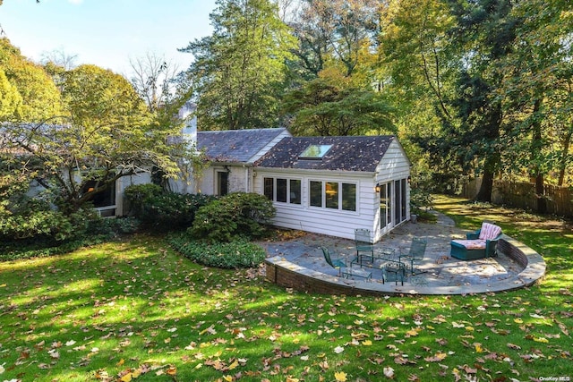 back of house featuring a lawn and a patio