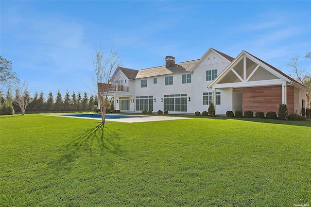 back of property featuring a lawn and a balcony