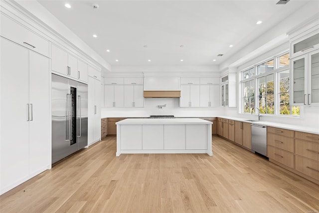 kitchen with stainless steel appliances, white cabinetry, and a large island