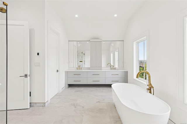 bathroom featuring vanity, vaulted ceiling, and independent shower and bath