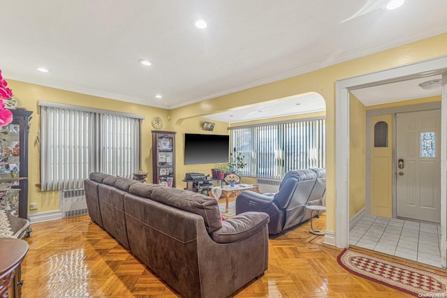 living room with a healthy amount of sunlight, radiator heating unit, ornamental molding, and light parquet floors