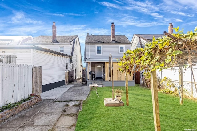 rear view of property featuring a yard