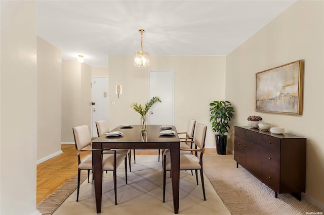 dining room featuring light parquet floors and a notable chandelier