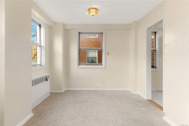 unfurnished room featuring carpet flooring and radiator