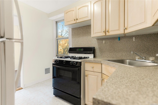 kitchen featuring decorative backsplash, gas stove, sink, and light brown cabinets