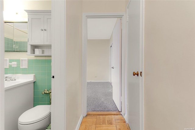 bathroom featuring vanity, toilet, and tile walls