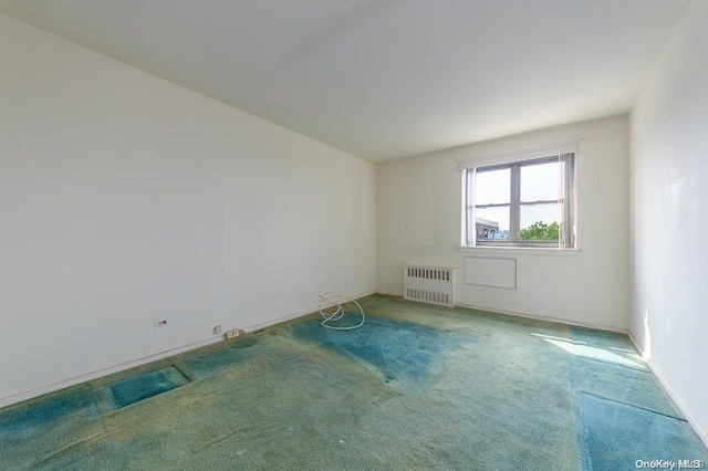 carpeted empty room with radiator