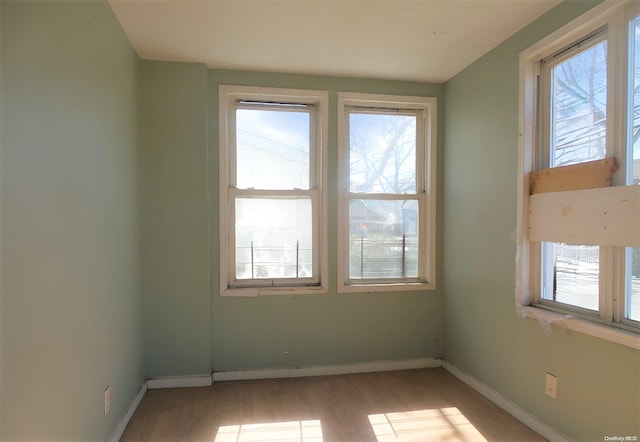 spare room with a wealth of natural light and light hardwood / wood-style floors