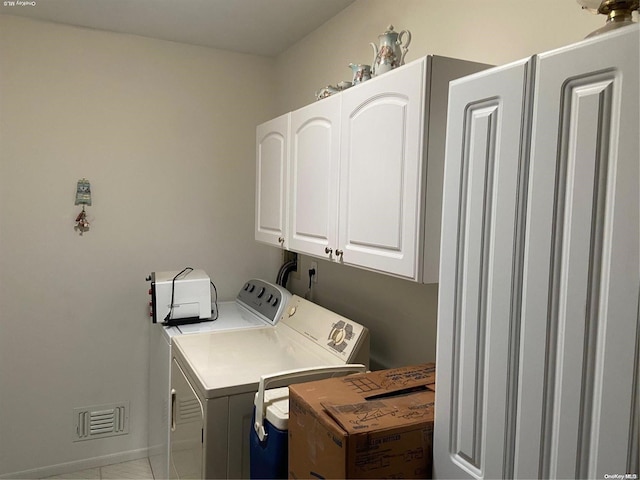 laundry area with washer and clothes dryer, cabinets, and light tile patterned floors