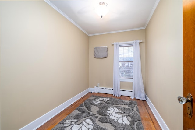 empty room featuring hardwood / wood-style flooring, ornamental molding, and a baseboard radiator