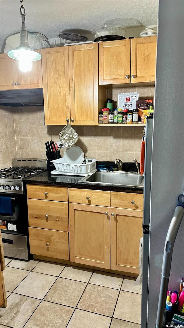 kitchen with backsplash, stainless steel gas range, extractor fan, sink, and light tile patterned floors