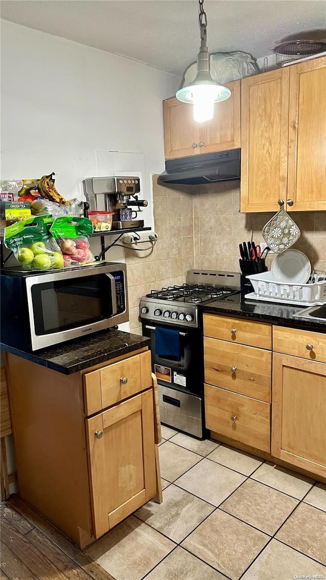 kitchen featuring decorative backsplash, appliances with stainless steel finishes, light tile patterned floors, and hanging light fixtures