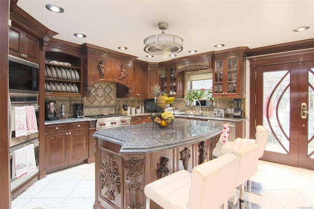 kitchen featuring tasteful backsplash, a center island, appliances with stainless steel finishes, and sink