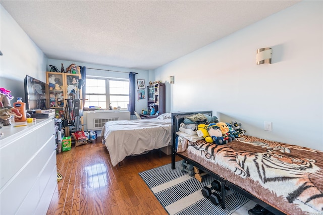 bedroom featuring a textured ceiling and dark wood-type flooring