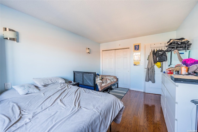 bedroom with a closet, dark wood-type flooring, and a textured ceiling