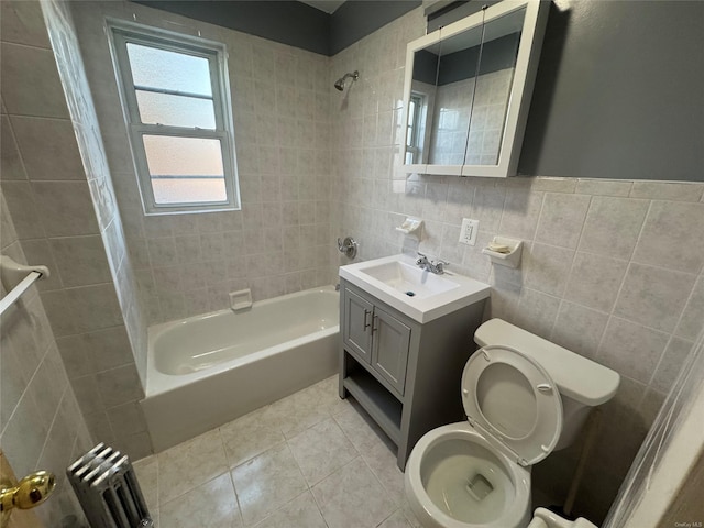 full bathroom featuring tile patterned floors, radiator, tiled shower / bath combo, tile walls, and toilet