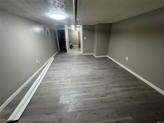 basement featuring a textured ceiling and hardwood / wood-style flooring