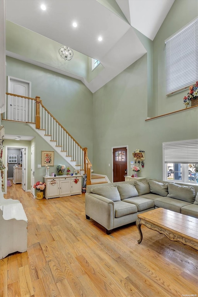 living room featuring a towering ceiling and light wood-type flooring