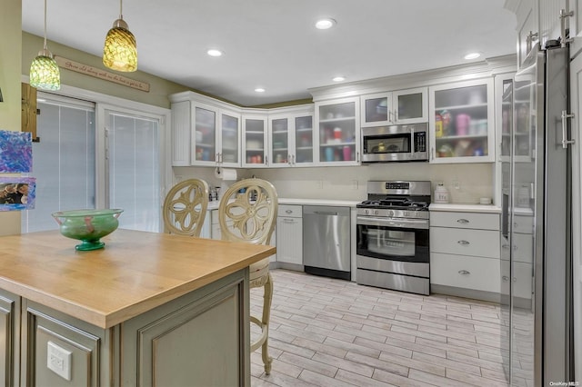 kitchen featuring white cabinetry, pendant lighting, and appliances with stainless steel finishes