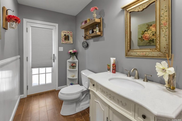 bathroom featuring vanity, wood-type flooring, and toilet