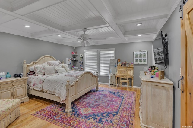 bedroom with beamed ceiling, coffered ceiling, a barn door, and light hardwood / wood-style floors