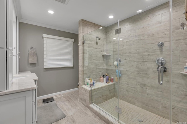 bathroom featuring a shower with door, crown molding, and vanity