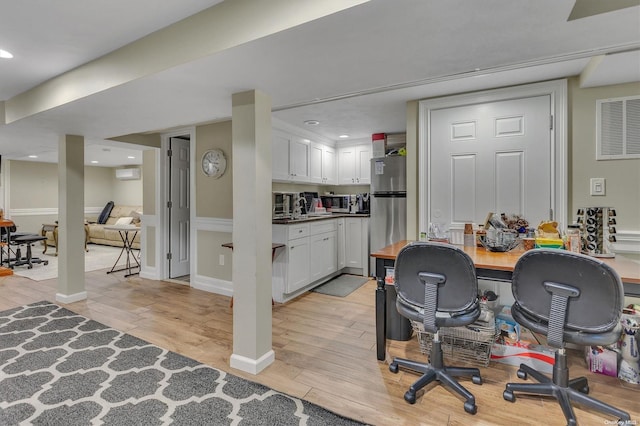 interior space featuring a wall mounted AC and light hardwood / wood-style flooring